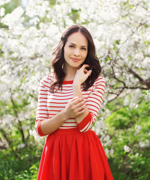 Zonnige portret van een mooie jonge vrouw in een bloeiende tuin — Stockfoto