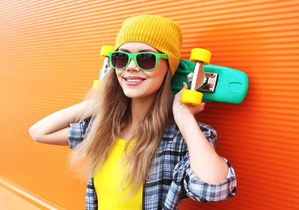 Модный портрет хипстерской крутой девушки в солнцезащитных очках со скейтбордом — стоковое фото