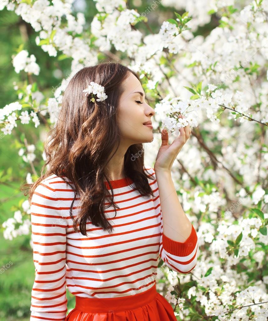 Portrait of a beautiful young woman in a flowering spring garden