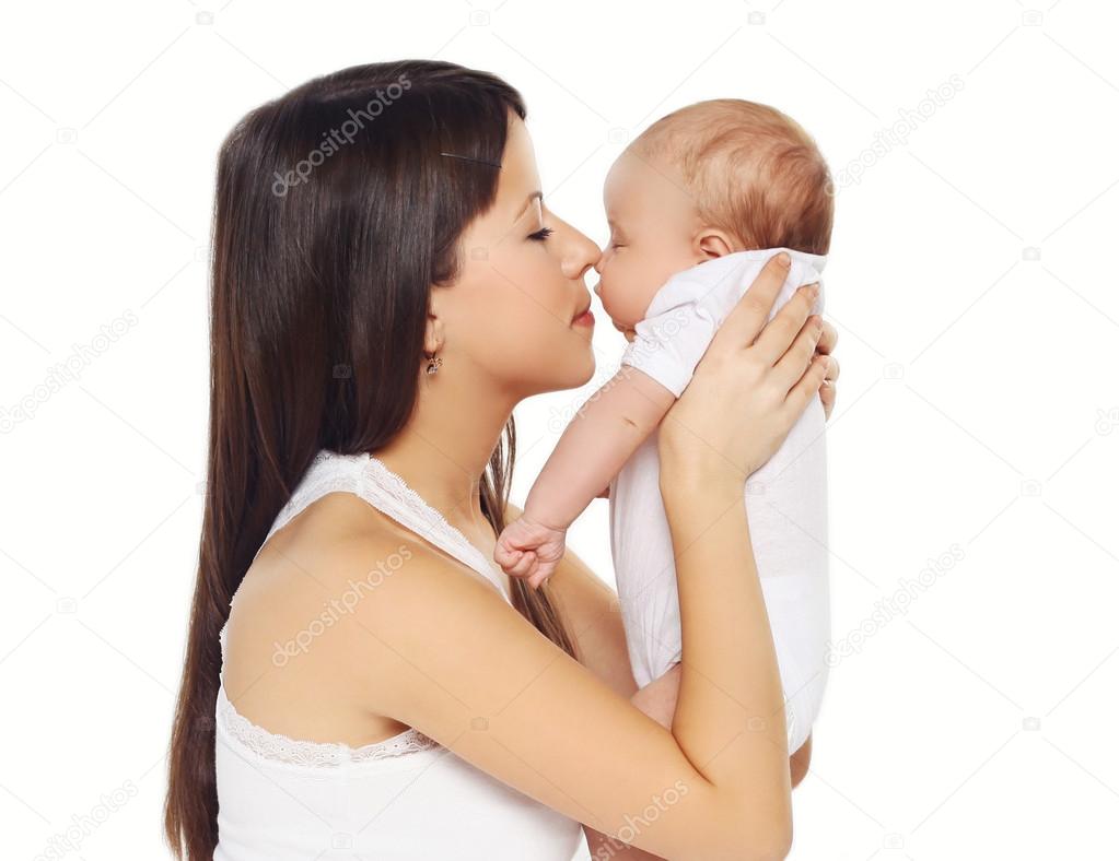 Portrait of young loving mother kissing cute baby 