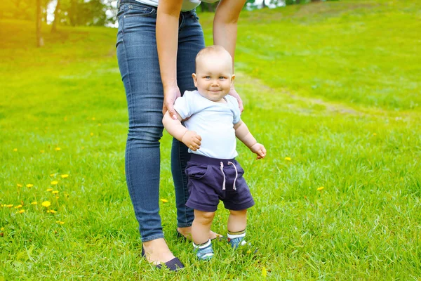 Mother and baby walking together on the grass in summer day — Stock Photo, Image