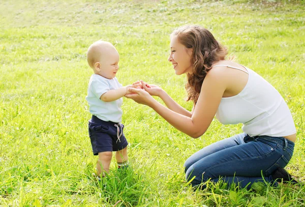 Mother playing with baby on the grass in summer day — Stock Photo, Image