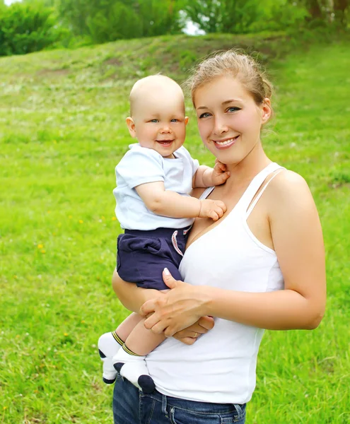 Портрет счастливой улыбающейся матери и сына ребенка на открытом воздухе в сумме — стоковое фото