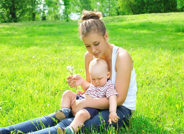 夏の日に草の上に座っている若い母と息子の子 — ストック写真