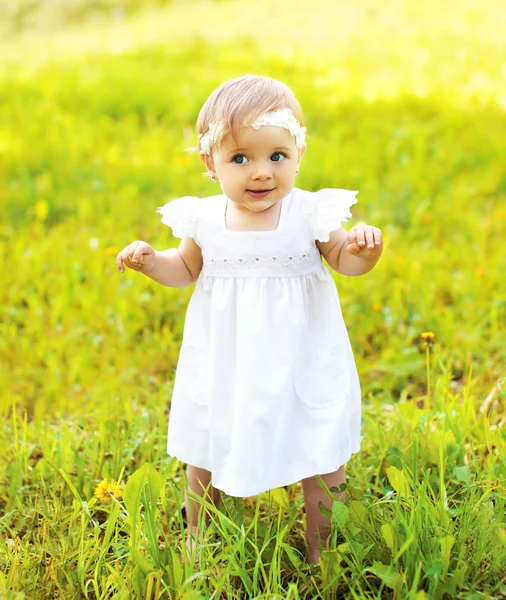 Bebê bonito andando na grama no dia ensolarado de verão — Fotografia de Stock