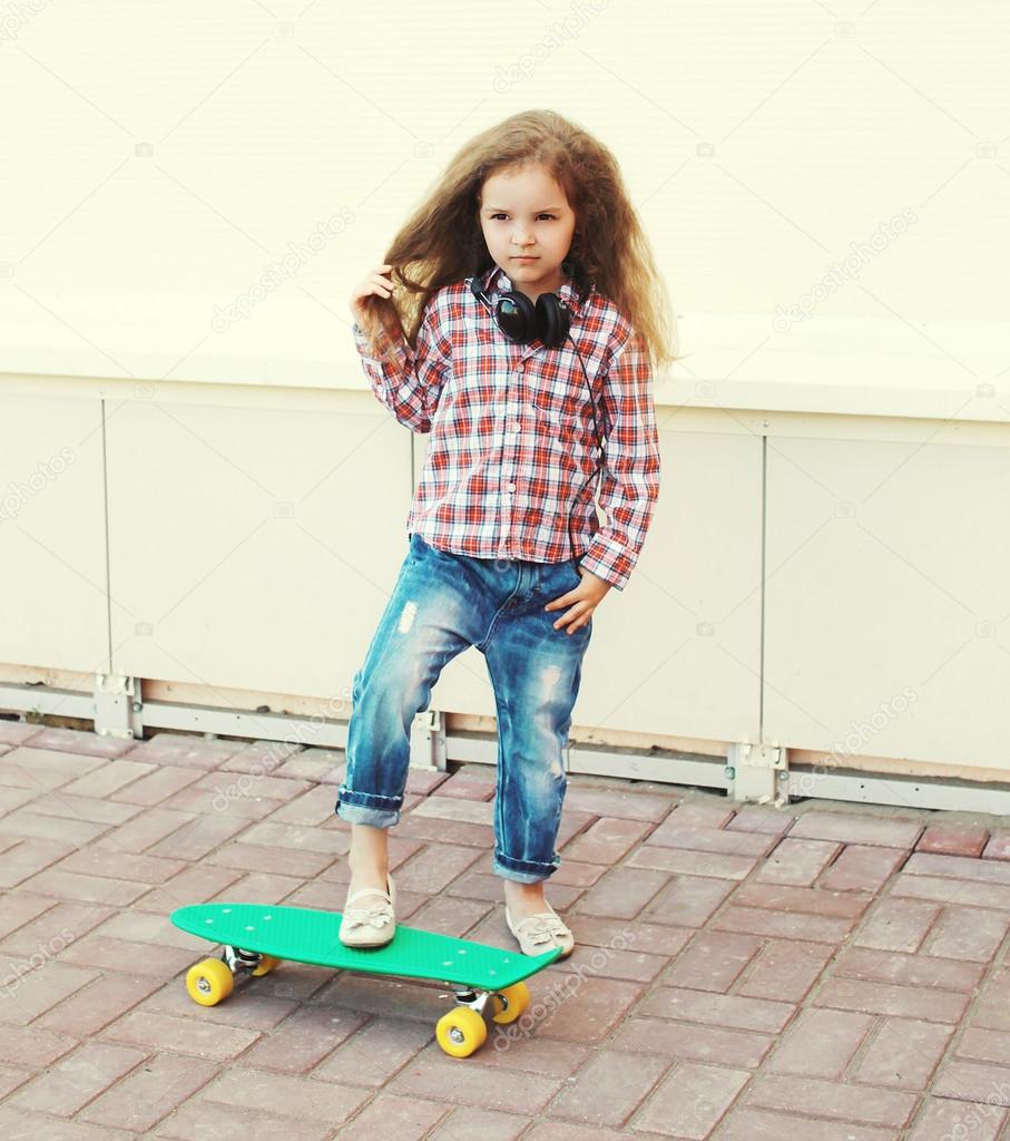 Fashion kid concept - stylish little girl child with skateboard 