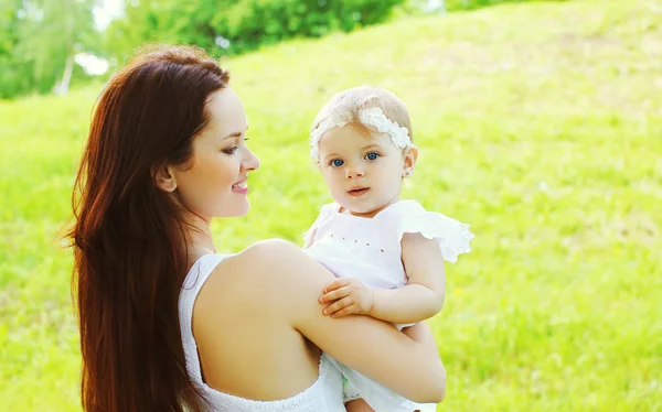 Happy loving mother and baby together outdoors in sunny summer d — Stock Photo, Image