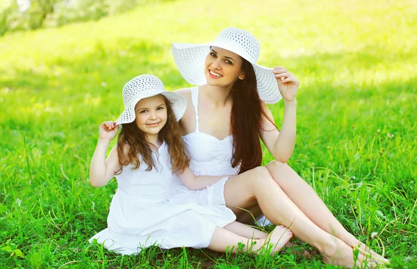 快乐的微笑母亲和女儿孩子戴着白色的稻草 — 图库照片