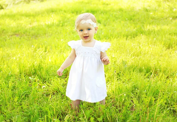 Ritratto di bambino carino che cammina sull'erba nella soleggiata giornata estiva — Foto Stock
