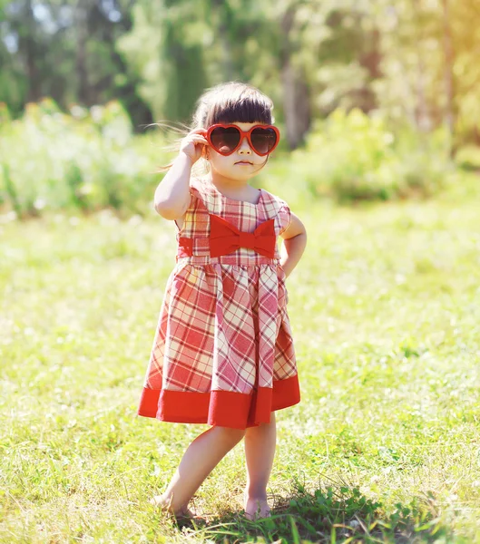 Дитина моди, маленька дівчинка дитина в сукні і червоний сонцезахисний — стокове фото