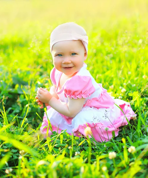 Retrato ensolarado de criança sorridente sentada na grama no verão d — Fotografia de Stock