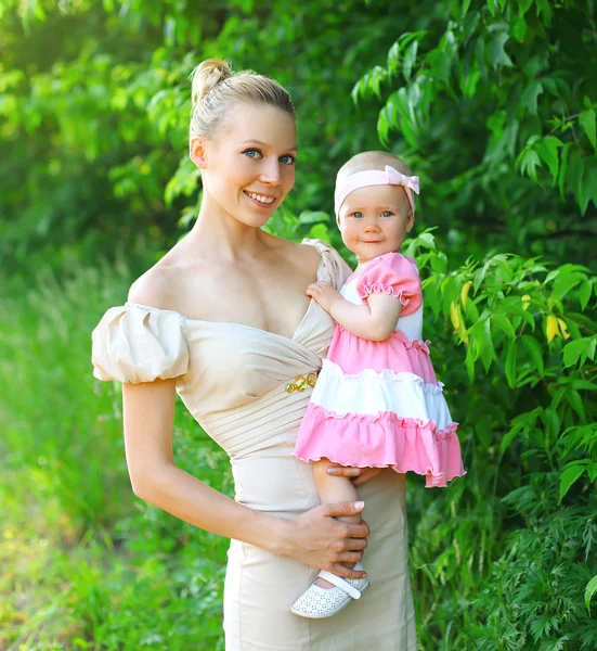 Retrato de la joven madre feliz y la hija del bebé con un vestido —  Fotos de Stock