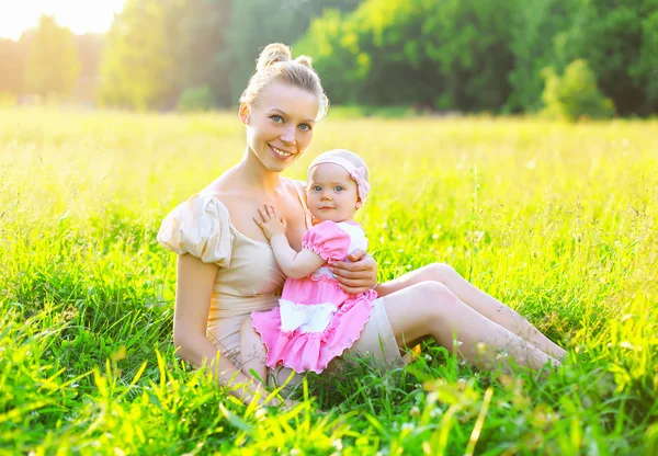 Retrato de feliz jovem mãe e bebê pequena filha vestindo — Fotografia de Stock