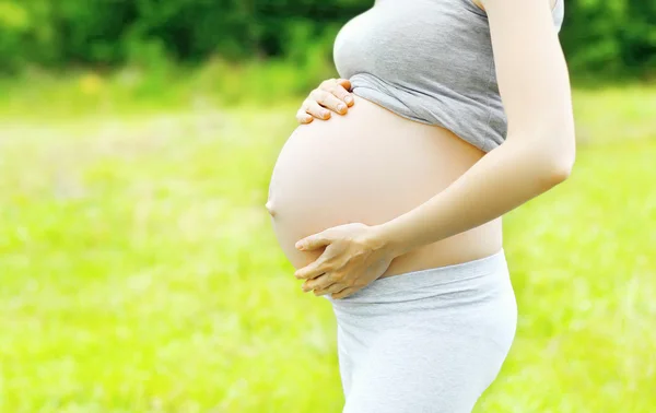 Pregnant young woman outdoors in warm summer day closeup — Stok fotoğraf