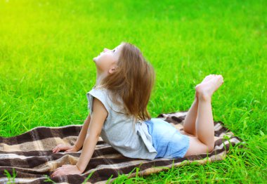 Küçük kız çocuk çim üzerinde yalan yoga egzersiz açık havada yok