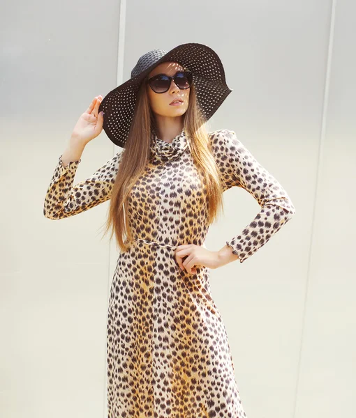 Portrait of beautiful woman wearing a leopard dress, straw hat a — ストック写真