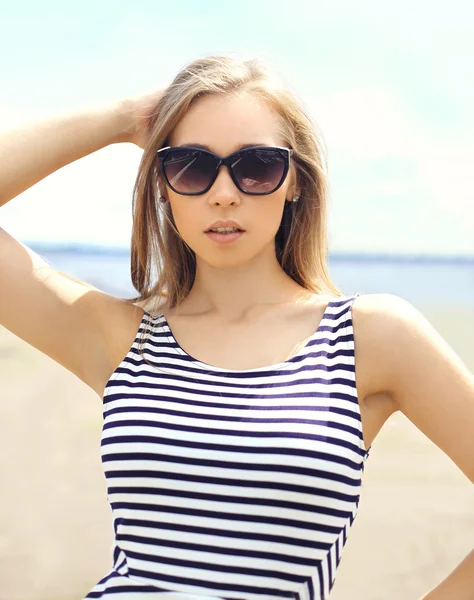 Portrait of beautiful young woman in sunglasses and striped dres — Stock Photo, Image