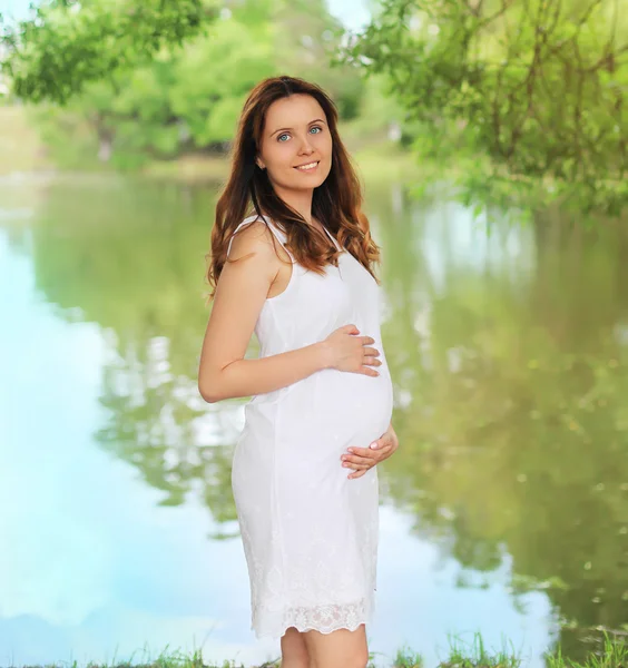 Retrato de bela jovem sorrindo mulher grávida em branco dres — Fotografia de Stock