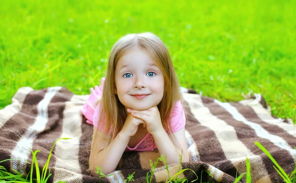 Porträt eines schönen kleinen Mädchens, das auf dem Gras liegt — Stockfoto