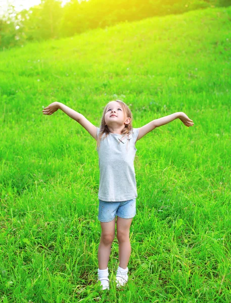 Niña disfrutando del día de verano, manos arriba, niño caminando en summ — Foto de Stock