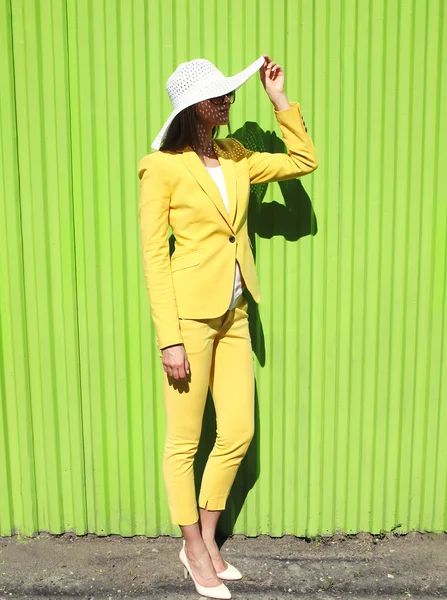 Fashion elegant woman wearing a yellow suit clothes and straw ha — ストック写真