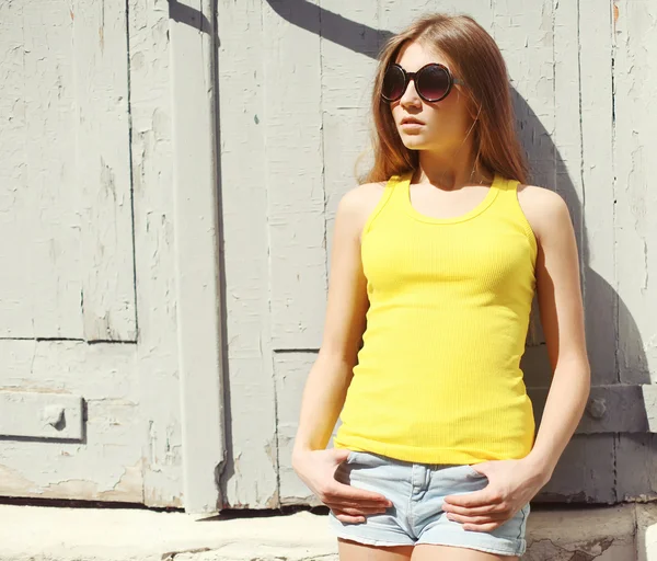 Retrato de una mujer joven y elegante con gafas de sol y camiseta — Foto de Stock