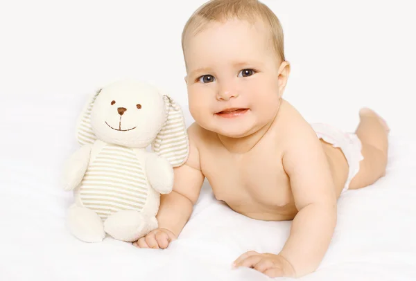 Cute baby with toy lying on the bed at home — Stock Photo, Image