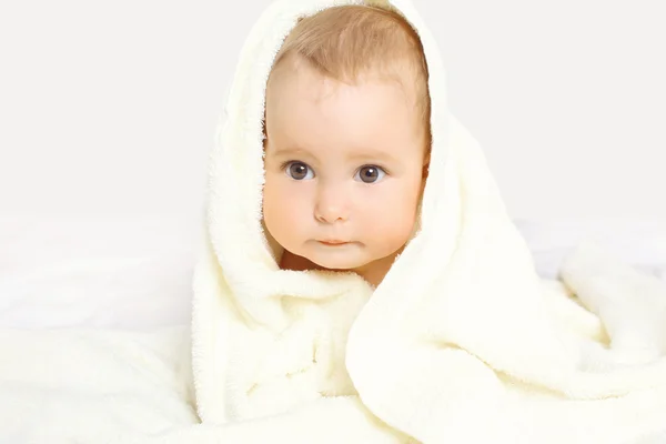 Closeup retrato de bebê bonito sob toalha na cama em casa — Fotografia de Stock