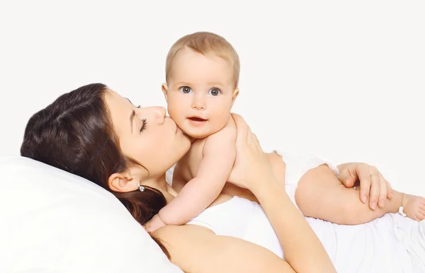 Mère embrasser bébé et couché sur le lit à la maison — Photo