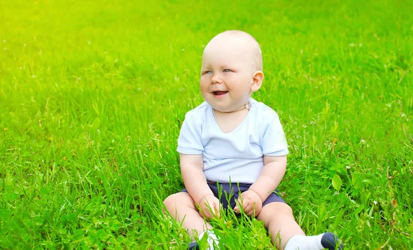 Baby sitting on the grass in sunny summer day — Stockfoto