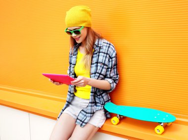 Fashion and technology concept - stylish pretty cool girl using 