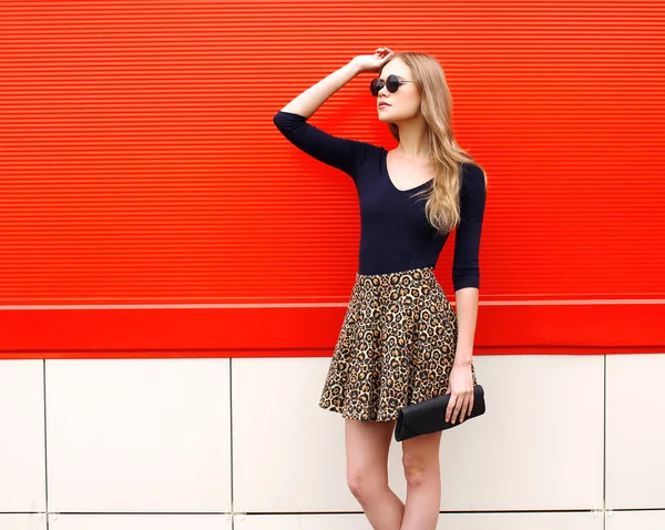 Fashion beautiful woman model in leopard skirt and sunglasses wi
