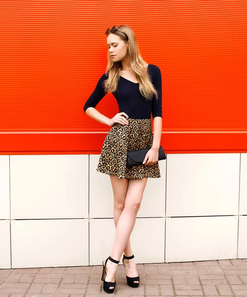 Moda hermosa mujer joven en falda de leopardo con clut bolso —  Fotos de Stock