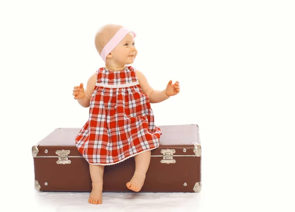 Niño feliz niña en vestido sentado en la maleta jugando —  Fotos de Stock