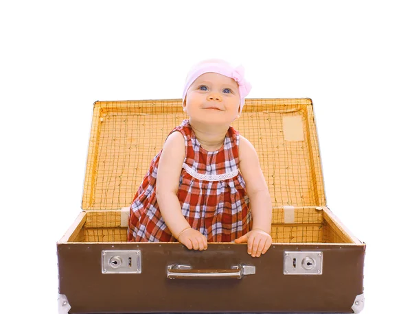 Счастливый ребенок, сидящий в чемодане и играющий и веселящийся — стоковое фото