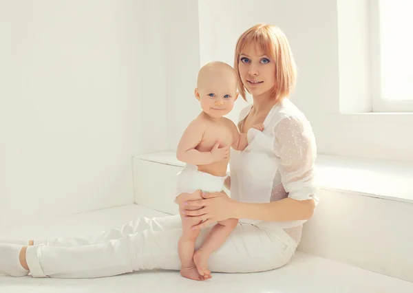 Madre y bebé juntos en habitación blanca en casa cerca de la ventana — Foto de Stock