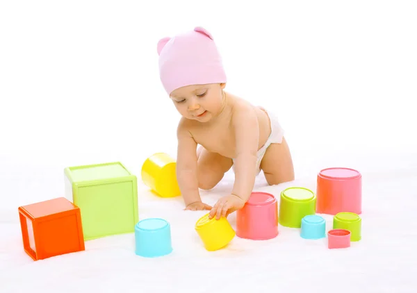 Портрет милого ребенка, играющего с множеством разноцветных игрушек — стоковое фото