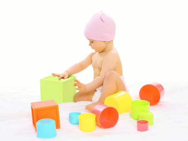 Портрет маленького ребенка, играющего со многими красочными игрушками — стоковое фото
