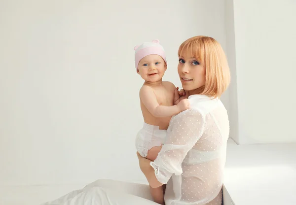 Retrato de la madre y el bebé juntos en habitación blanca en casa cerca —  Fotos de Stock