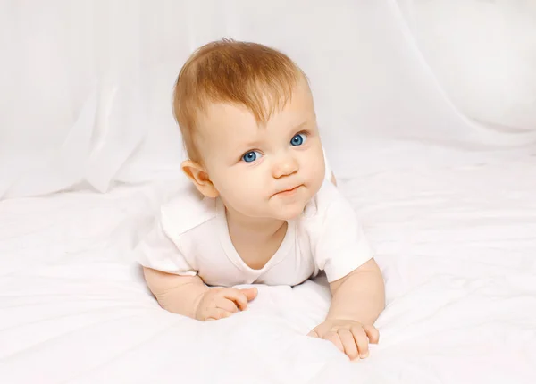 Porträt eines Babys, das zu Hause in Großaufnahme auf dem Bett liegt — Stockfoto