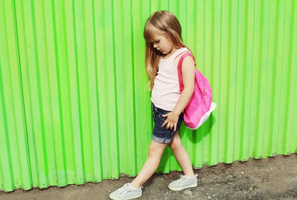 Little girl child with backpack in profile against the colorful — Stock fotografie