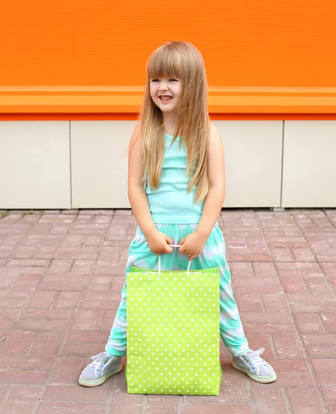 Portrait of beautiful little girl child with shopping bag agains — Zdjęcie stockowe