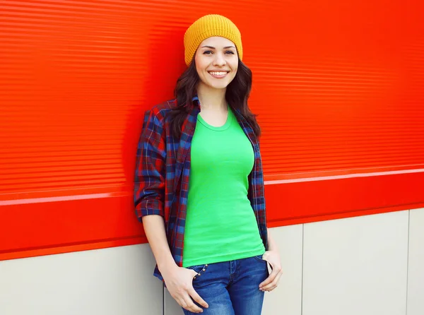 Pretty smiling young woman in casual clothes over colorful wall — Stock Photo, Image