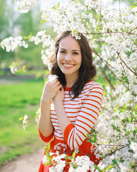 Portret van mooie lachende jonge vrouw in de bloei voorjaar ga — Stockfoto