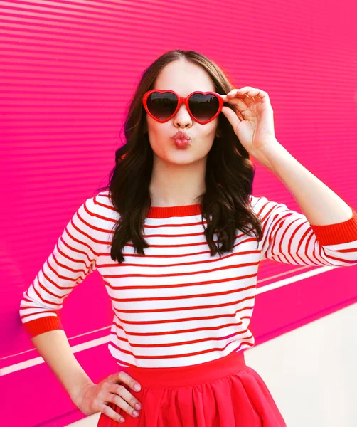 Retrato de mujer bastante dulce en gafas de sol rojas soplando labios ha — Foto de Stock