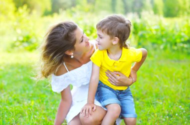 Happy mother with child son together outdoors in summer day