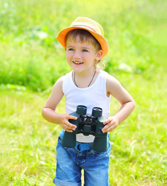 Happy child boy with binoculars outdoors in summer day — Stock fotografie