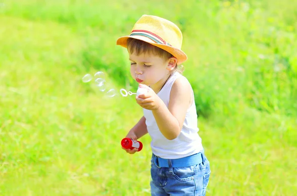 Little boy child blowing soap bubbles outdoors in sunny summer d — Stok fotoğraf