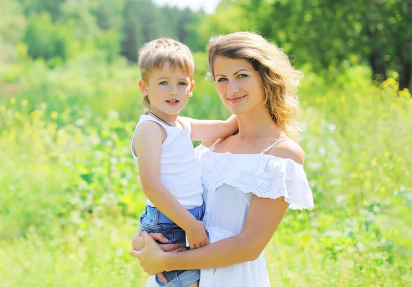 Portrait of happy mother hugging child son outdoors in summer da — Φωτογραφία Αρχείου