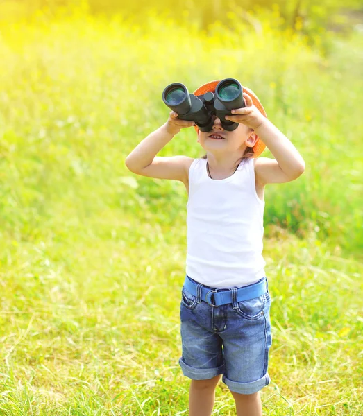 Soliga foto barn pojke ser ut i kikare utomhus i sommardag — Stockfoto